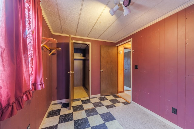 bedroom featuring wood walls, baseboards, ornamental molding, and tile patterned floors