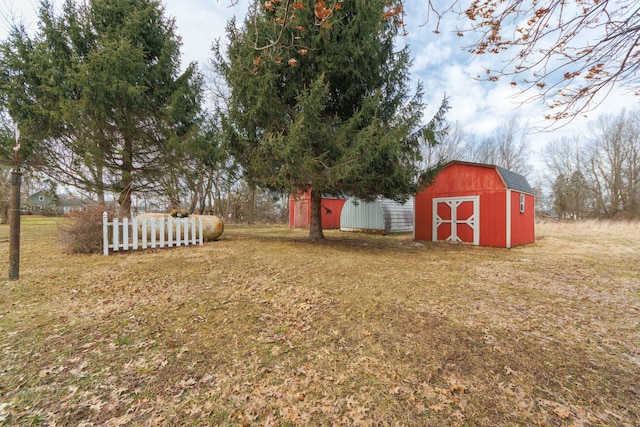 view of yard featuring an outdoor structure, a shed, and fence