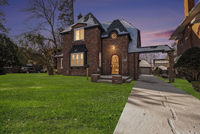 view of front facade with a garage, an outbuilding, brick siding, and a front lawn