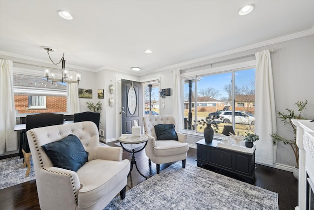 living area with dark wood-style floors, crown molding, baseboards, and an inviting chandelier