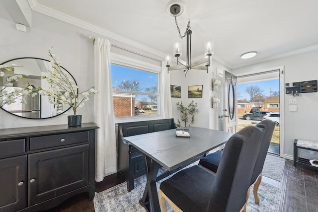 dining room featuring dark wood-style floors, ornamental molding, baseboards, and an inviting chandelier