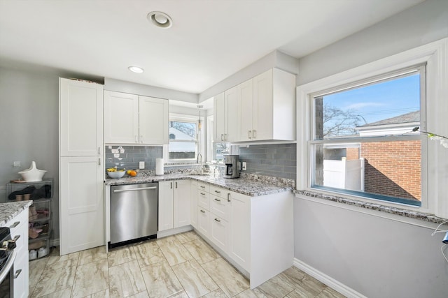 kitchen with light stone countertops, tasteful backsplash, white cabinetry, and dishwasher