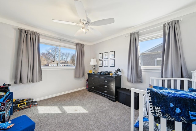 carpeted bedroom with ceiling fan, multiple windows, baseboards, and ornamental molding