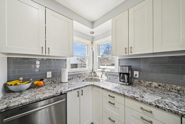 kitchen with a sink, decorative backsplash, white cabinets, and dishwasher