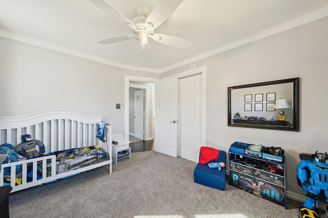 carpeted bedroom with a ceiling fan, a closet, and crown molding