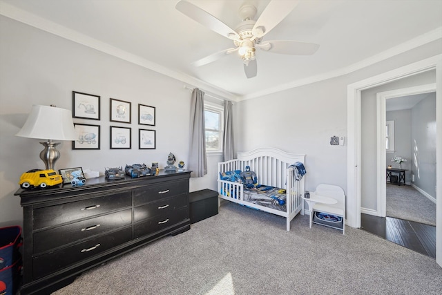 carpeted bedroom featuring baseboards, a ceiling fan, and crown molding