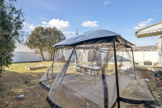 view of patio / terrace with a garden, a fenced backyard, and a gazebo