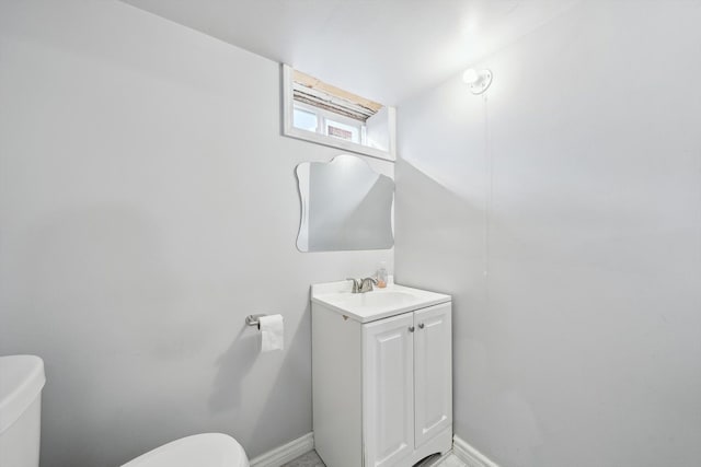 bathroom featuring vanity, toilet, and baseboards