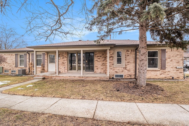 ranch-style house with a patio, a front lawn, cooling unit, and brick siding