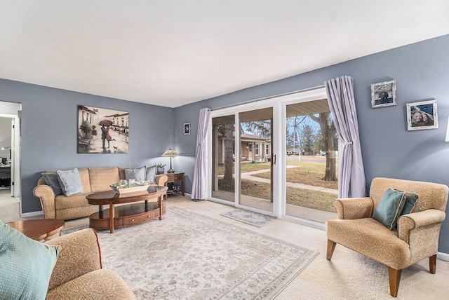 carpeted living area with baseboards