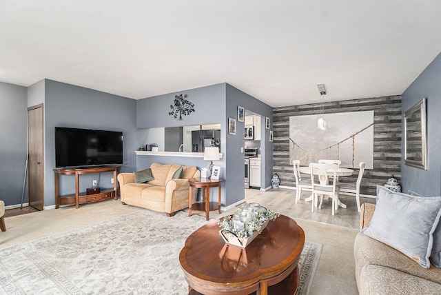 living room featuring an accent wall and baseboards