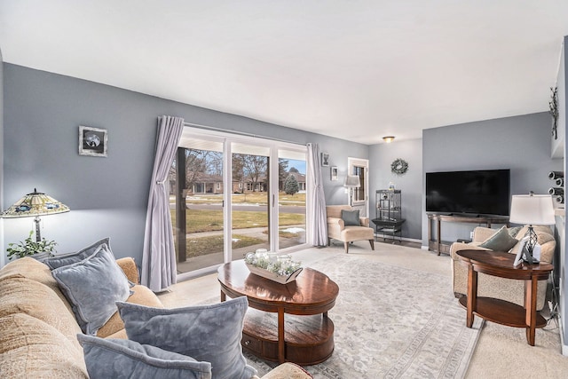 living room featuring light carpet and baseboards