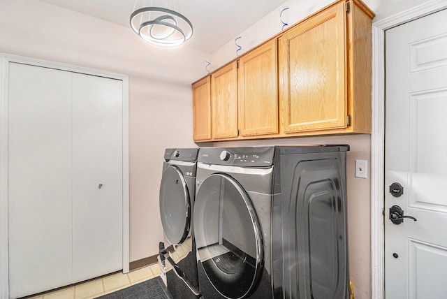 laundry area with cabinet space, light tile patterned floors, and independent washer and dryer