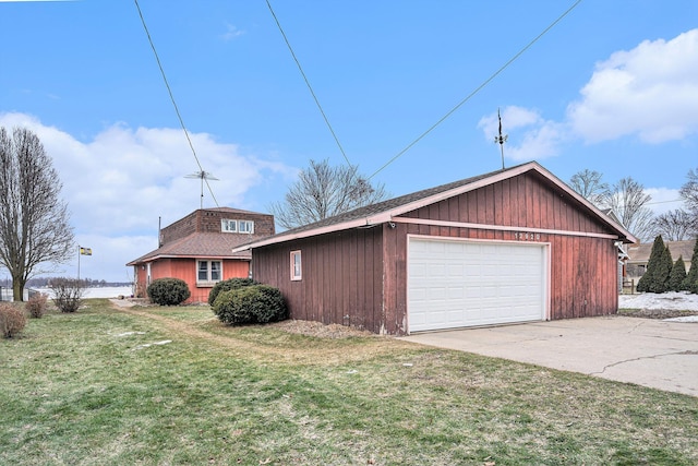 view of front of house featuring a garage, a shingled roof, and a front lawn