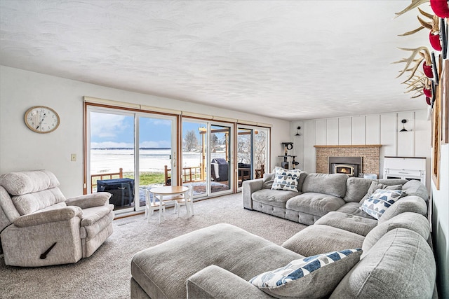 carpeted living area featuring a lit fireplace and a textured ceiling