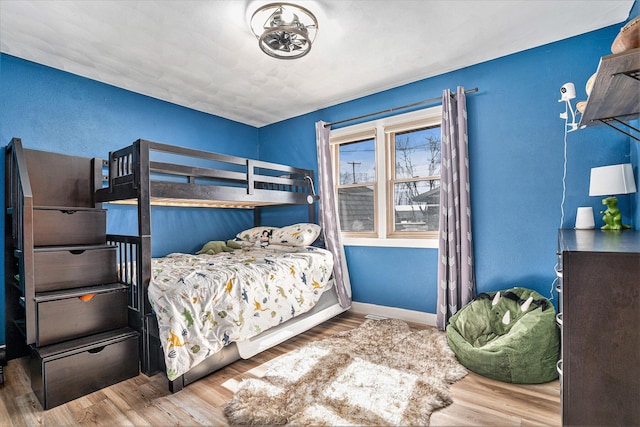 bedroom with baseboards and wood finished floors