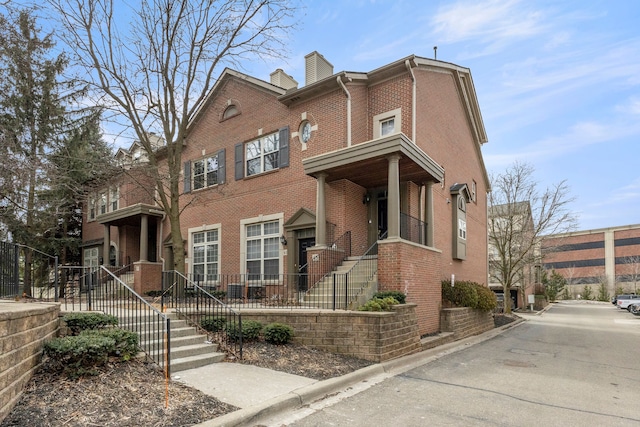 townhome / multi-family property featuring brick siding and a chimney