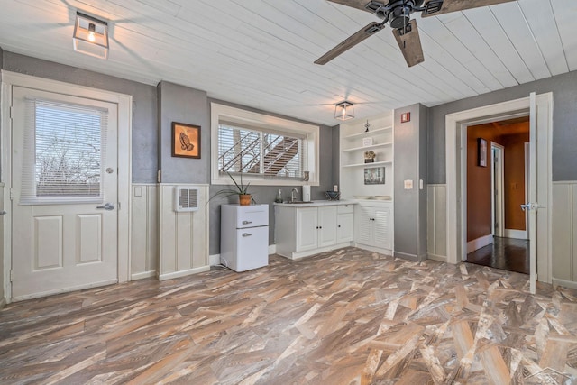 kitchen with a sink, wood ceiling, ceiling fan, and plenty of natural light