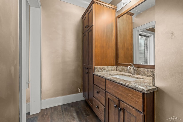 bathroom with vanity, baseboards, and wood finished floors