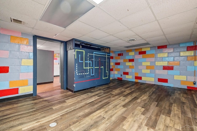 interior space with a paneled ceiling, visible vents, and wood finished floors