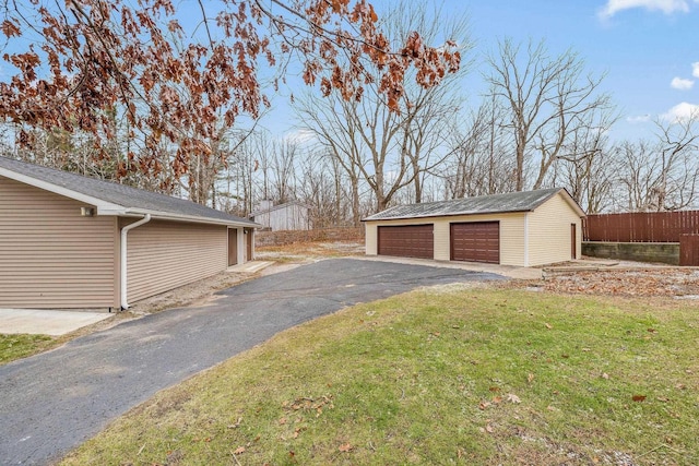 view of yard featuring a garage, an outdoor structure, and fence