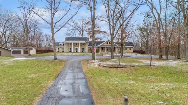 neoclassical / greek revival house featuring aphalt driveway and a front lawn