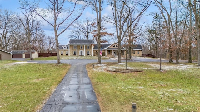 neoclassical / greek revival house featuring a garage, aphalt driveway, and a front yard