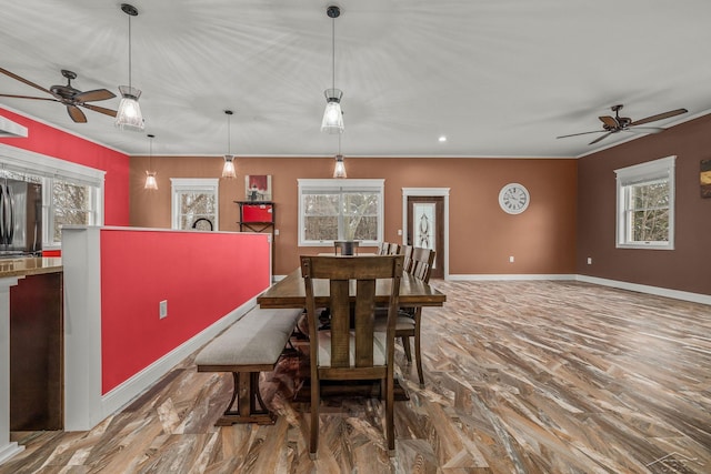 dining area with baseboards, a ceiling fan, and plenty of natural light