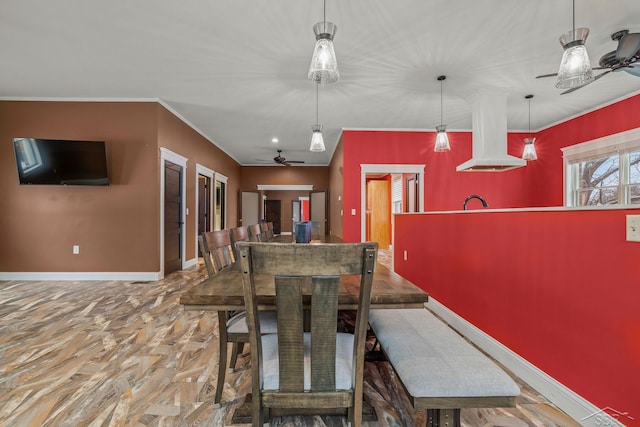 dining area with a ceiling fan, crown molding, and baseboards