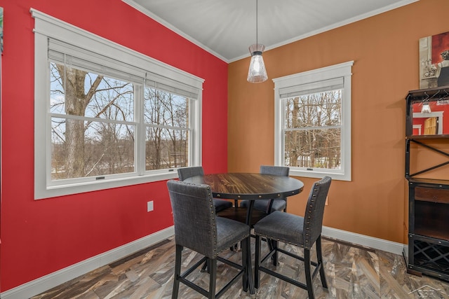 dining room with a healthy amount of sunlight, baseboards, and ornamental molding