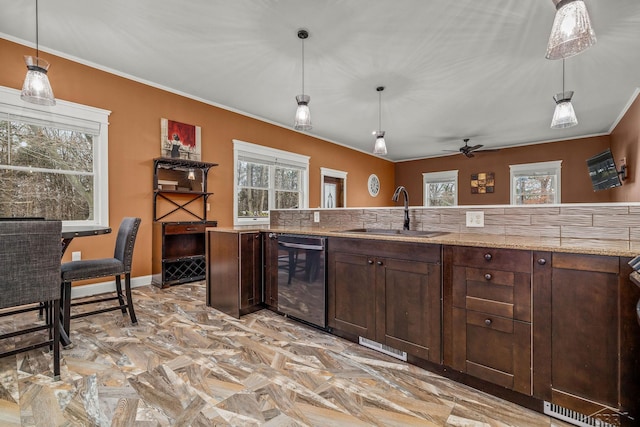 kitchen featuring crown molding, hanging light fixtures, dark brown cabinetry, a sink, and dishwashing machine