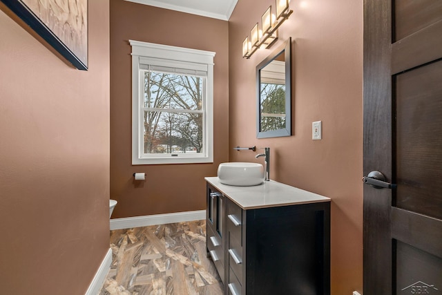 half bathroom featuring baseboards, crown molding, and vanity