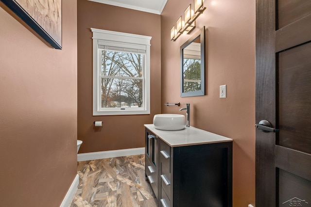 half bathroom featuring ornamental molding, vanity, and baseboards