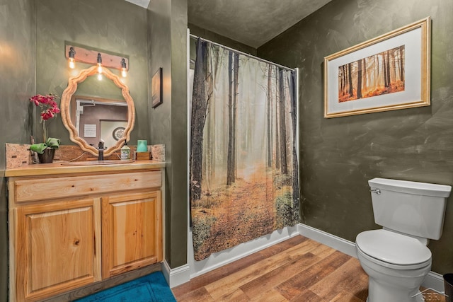 bathroom with vanity, curtained shower, toilet, baseboards, and wood finished floors