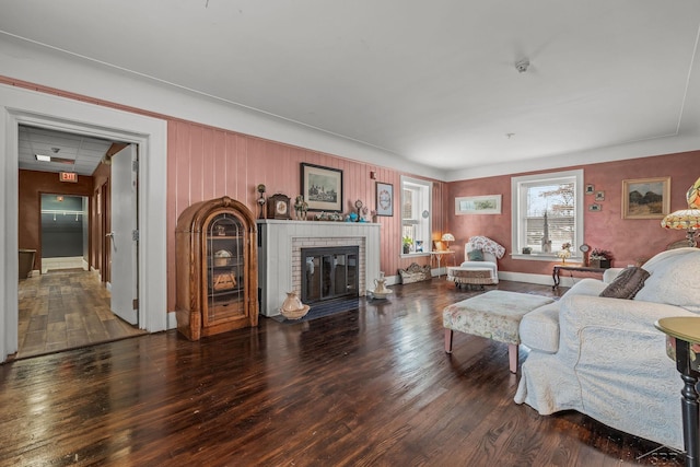 living area with baseboards, wood finished floors, and a fireplace