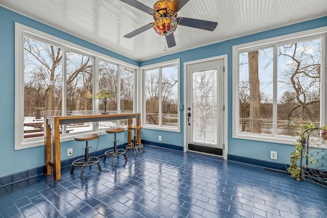 sunroom / solarium featuring ceiling fan and plenty of natural light