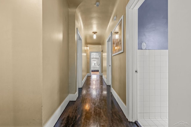 hall with baseboards and dark wood finished floors