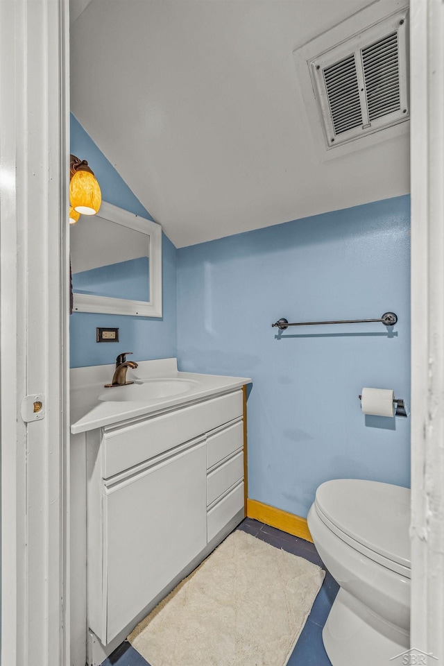 half bath with toilet, vanity, visible vents, vaulted ceiling, and baseboards