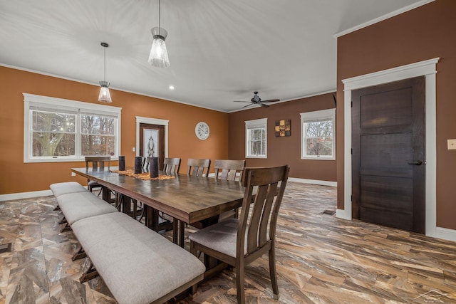 dining area with ceiling fan, crown molding, and baseboards