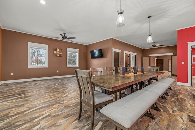 dining space featuring crown molding, baseboards, and ceiling fan