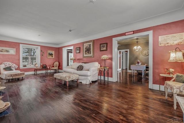 living area with a notable chandelier, wood finished floors, and baseboards