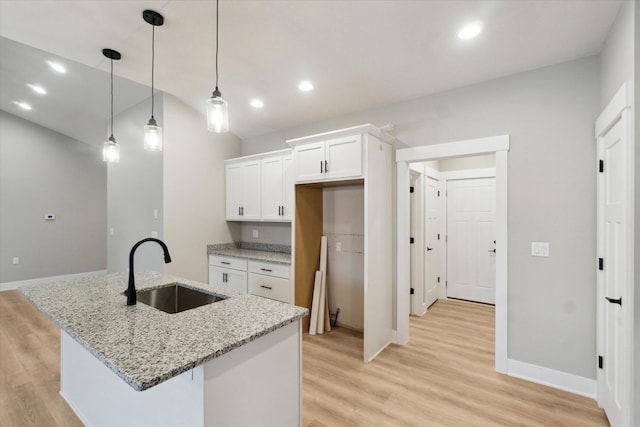 kitchen with recessed lighting, light wood-type flooring, a sink, and white cabinets