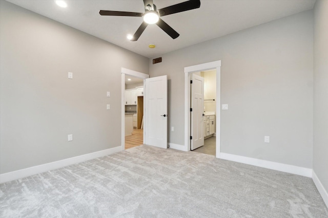 unfurnished bedroom featuring visible vents, connected bathroom, light carpet, and baseboards