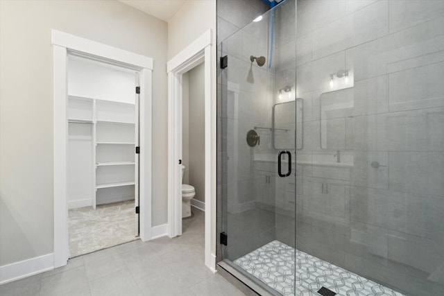 full bath with baseboards, a shower stall, toilet, and tile patterned floors