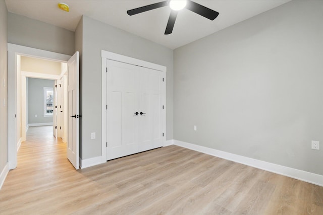 unfurnished bedroom featuring a closet, light wood-style flooring, and baseboards