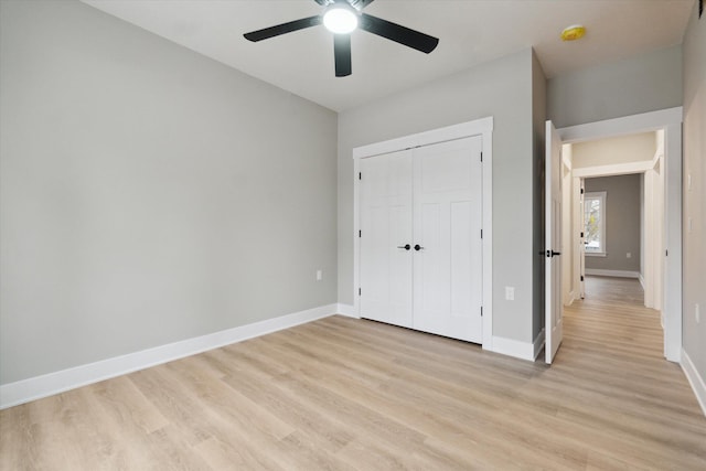 unfurnished bedroom with light wood-style floors, a closet, ceiling fan, and baseboards