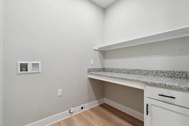 clothes washing area with hookup for a washing machine, cabinet space, light wood-style floors, electric dryer hookup, and baseboards