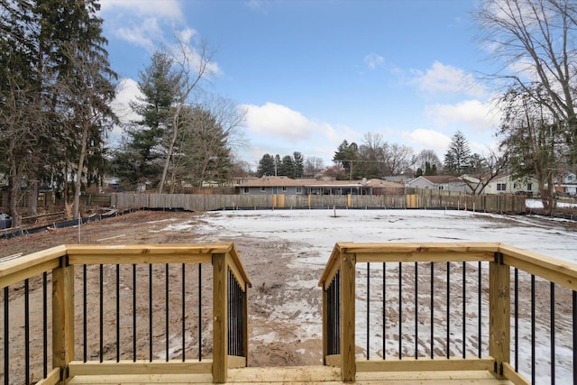 snow covered deck with a residential view and a fenced backyard