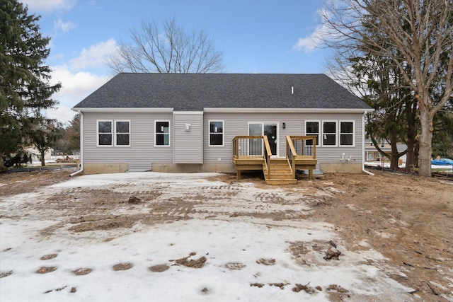 back of house featuring roof with shingles and a deck