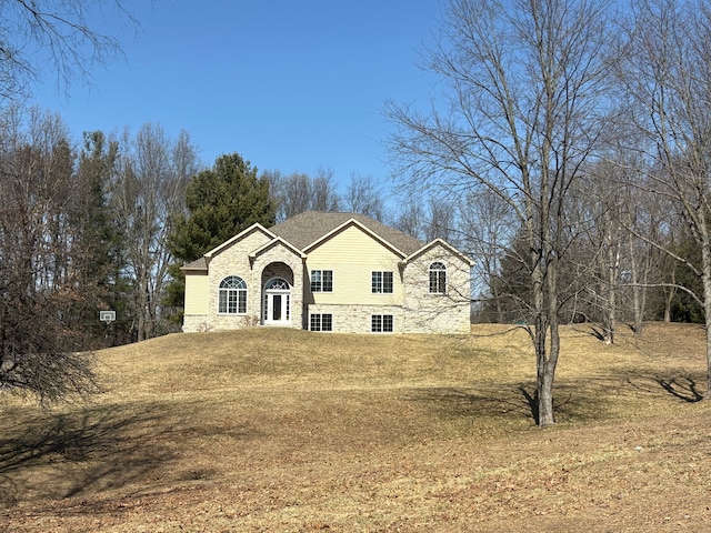 view of front of home featuring a front yard and stone siding